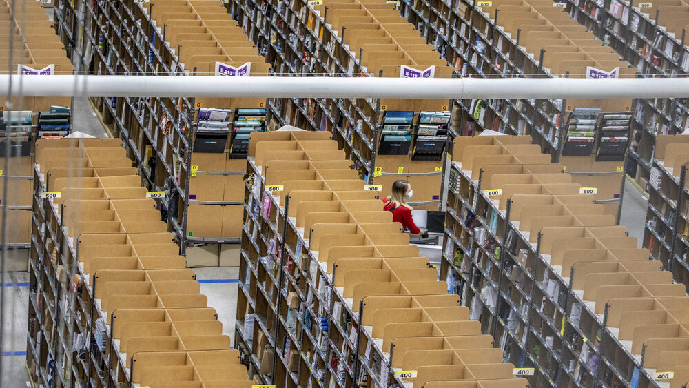 BRIESELANG, GERMANY - NOVEMBER 18: A worker pushes a cart laden with ordered items among shelves at an Amazon warehouse on November 18, 2021 in Brieselang, Germany. Many shoppers who fear gifts will be lacking due to the global supply chain disruption are buying their Christmas gifts early this year, both online and at brick and mortar retailers. (Photo by Maja Hitij/Getty Images)