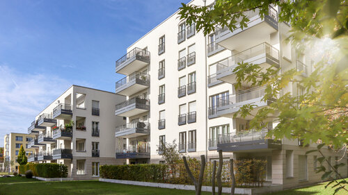 Stadtbild mit modernem Wohngebiet, neuen Wohngebäuden und grünem Innenhof mit Fußgängerweg und Bäumen im Herbst. Stadtbild mit modernem Wohngebiet, neuen Wohngebäuden und grünem Innenhof mit Fußgängerweg und Bäumen im Herbst.
