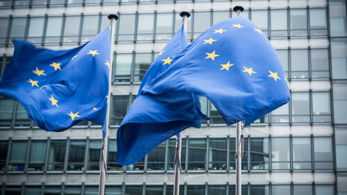 "European flags in front of the European Commission headquarters in Brussels, Belgium. ( Motion Blurred on flags)"