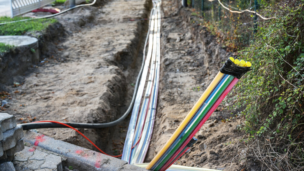 Construction site for installing fiber optic cables under the ground beside a street to bring fast internet to all residents, selected focus, narrow depth of field