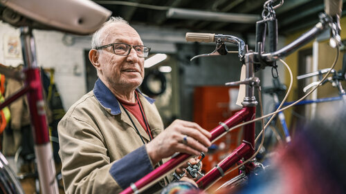 Älterer Mann arbeitet in seinem Fahrradladen. Älterer Mann arbeitet in seinem Fahrradladen.